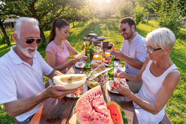 自然の中でランチを楽しみながら二世代 レジャー 食べ物 人々と休暇の概念 — ストック写真