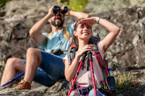 Dürbünle dağlara bakan neşeli bir çift. Doğa, yürüyüş, insan ve yaşam tarzı kavramından sonra dinleniyorlar..