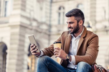 Molada akıllı telefon kullanan yakışıklı bir iş adamı. İş, insan ve teknoloji kavramı.