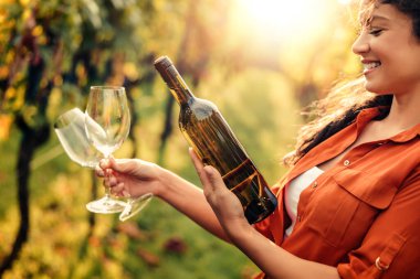 Üzüm bağlarında şarap içen esmer bir kadının portresi..