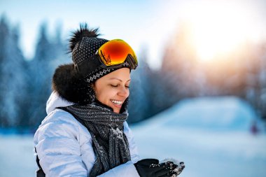 Kışın parktaki kadın. Açık havada. Güneşli bir gün. Neşeli kadın kış parkında eğleniyor.. 