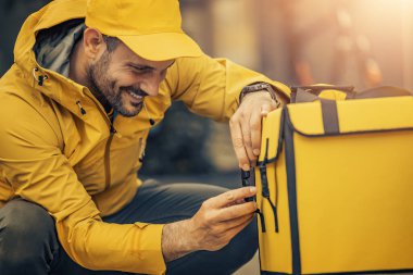 Young man in uniform as a courier delivering food.Food delivery.