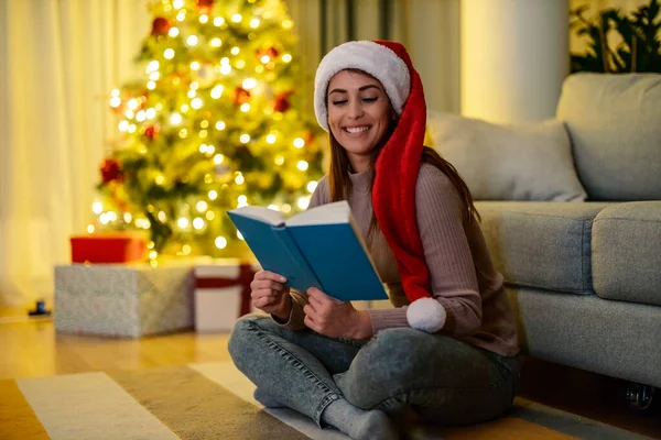 Smiling Woman Sweater Sitting Next Christmas Tree Reading Book — Stock Photo, Image