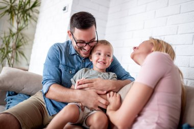 Mutlu aile evde birlikte eğleniyor. Anne ve baba oğluyla oynuyor. Aşk, aile ve yaşam tarzı kavramı.