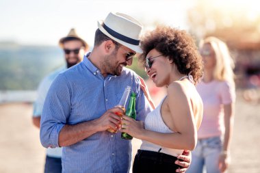 Romantik çift rahatlatıcı ve plajda bira içme.