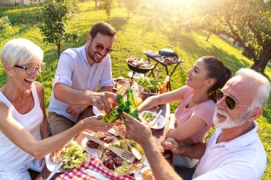 Mutlu aile doğada yemek yerken eğleniyor..