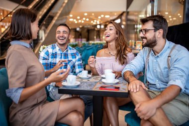 Arkadaşlar restoranda harika vakit geçiriyorlar. Bir grup insan bir kafede oturup kahve içiyor..