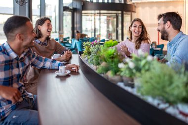 Genç arkadaşlar restoranda harika vakit geçiriyorlar. Bir kafede oturan bir grup genç..