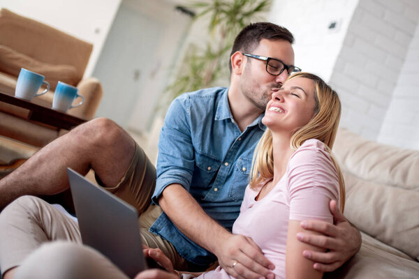 Love, family, technology and happiness concept.Smiling happy couple with laptop at home.