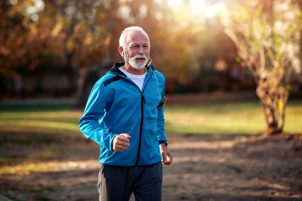 Senior man in sports wear running  outdoors.
