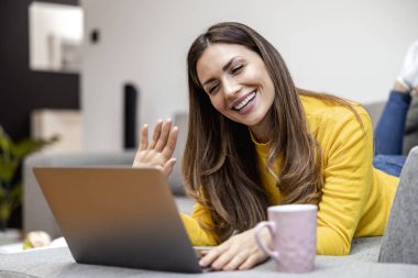 Güzel bir kadın görüntülü görüşme yapıyor. Evden çalışan genç bir kadın. Çevrimiçi konsept..