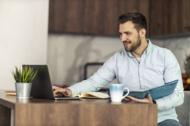 Evde çalışan genç bir adam. Merkez ofis, uzaktan çalışma konsepti..