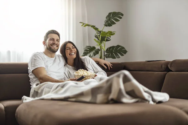 Young Happy Couple Watching Movie Eating Popcorn While Relaxing Living — стоковое фото