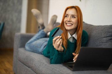 Dizüstü bilgisayar kullanan, e-posta yazan, çevrimiçi toplantı ya da ödeme yapan bir kadın. İnternetten alışveriş..
