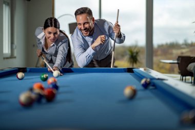 Başarılı iş adamları bilardo oynuyor, iş gününden sonra birlikte eğleniyorlar..