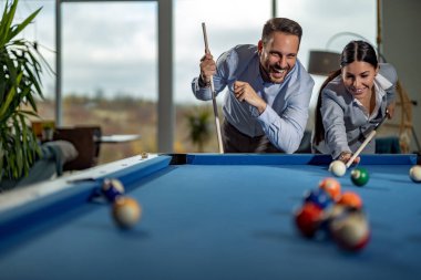 Başarılı iş adamları bilardo oynuyor, iş gününden sonra birlikte eğleniyorlar..