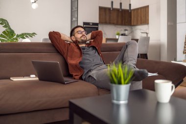 Dizüstü bilgisayar kullanan, e-posta yazan, online görüşme ya da internet üzerinden ödeme yapan bir adam. Ev ofisinden çalışan serbest çalışan biri..