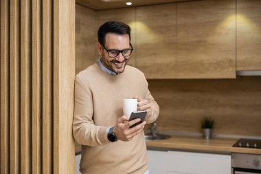 Frelancer ara veriyor, akıllı telefon kullanıyor ve ev ofisinden çalışıyor. İnternetten alışveriş..