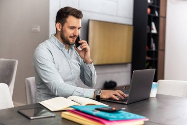 Dizüstü bilgisayar kullanan, e-posta yazan, online görüşme ya da internet üzerinden ödeme yapan bir adam. Ev ofisinden çalışan serbest çalışan biri..