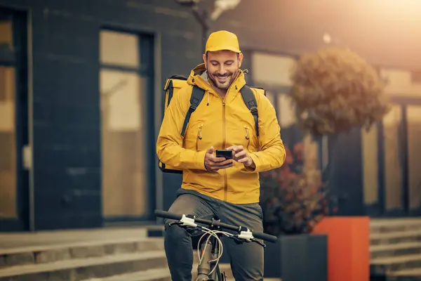 Home delivery,food and people concept-happy smiling delivery man using smartphone.Delivery service.