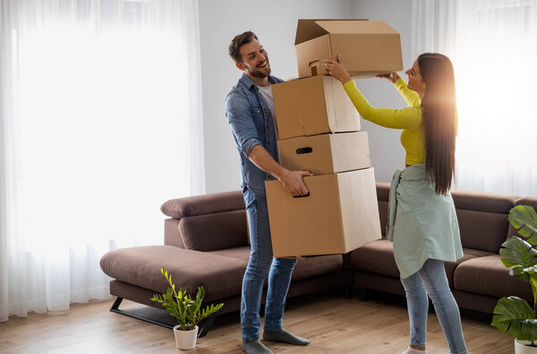Happy young married couple moves to new apartment and unpaking boxes.Happy moments together.