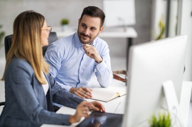 Ofiste çalışan ve yeni web sitesi planlayan web tasarımcıları. Bilgisayar kullanarak bir ofiste buluşan yaratıcı insanlar yeni planlar hakkında konuşuyorlar..