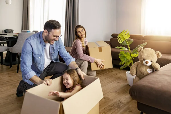 Happy family with child moving with boxes in a new apartment house.Family unpacking boxes in new home.