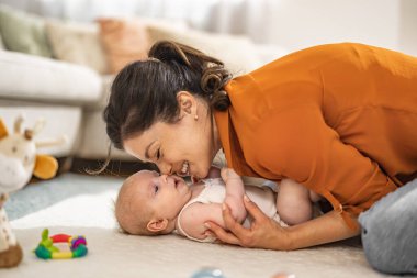 Sevgi dolu anne, yeni doğmuş bebeğini evde taşıyor. Anne ve bebeğin sevgisi. Aile evde..
