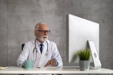 Çevrimiçi doktor randevusu. Online danışmanlık yapan kıdemli erkek doktor..