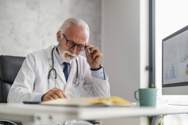 Çevrimiçi doktor randevusu. Online danışmanlık yapan kıdemli erkek doktor..