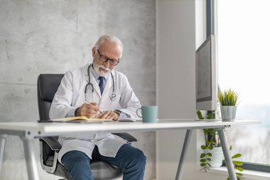 Çevrimiçi doktor randevusu. Online danışmanlık yapan kıdemli erkek doktor..