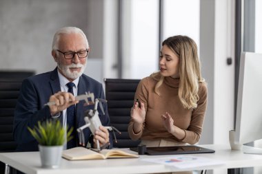 Kıdemli mühendis ve teknisyen modern ofiste yeni bir proje üzerinde birlikte çalışıyorlar..