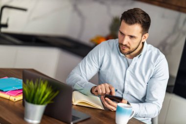 Evde çalışan genç bir adam. Merkez ofis, uzaktan çalışma konsepti..