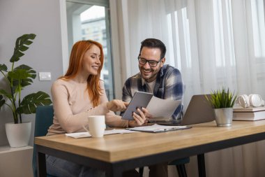 Başarılı iş çifti ev işlerinde birlikte çalışıyor. Takım çalışması konsepti. Aile şirketi kurma..