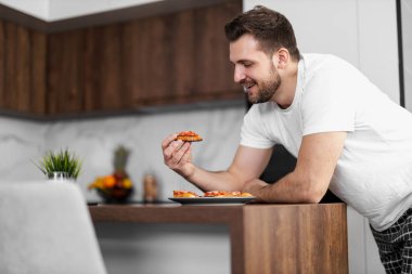 Happy single man having breakfast in the kitchen. People,food and drink concept. clipart