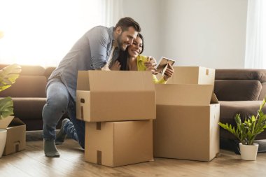 Smiling couple unpacking boxes in new home.New life.