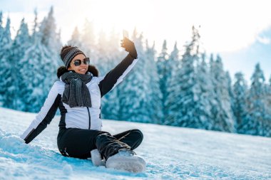 Kadın tatilde selfie çekiyor. Kış tatili kavramı. İnsanlar, seyahat ve doğa kavramı..