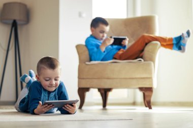 Dijital tablette video oyunu oynayan çocuklar. İnsanlar, eğlence ve teknoloji kavramı..