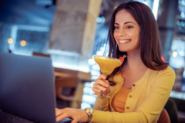 Modern kahve dükkanında dizüstü bilgisayarı olan genç bir bayan serbest yazar. İnsanlar, iş ve teknoloji kavramı..