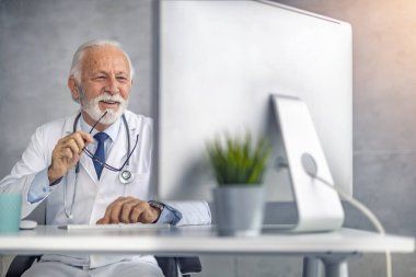 Çevrimiçi doktor randevusu. Online danışmanlık yapan kıdemli erkek doktor..