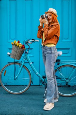 Analog kamerayla fotoğraf çeken genç bir kadın. İnsanlar, seyahat ve yaşam tarzı konsepti.