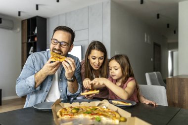 Mutlu aile hafta sonu birlikte eğleniyor. Mutlu aile kavramı. Öğle yemeğinde pizza yiyorlar..