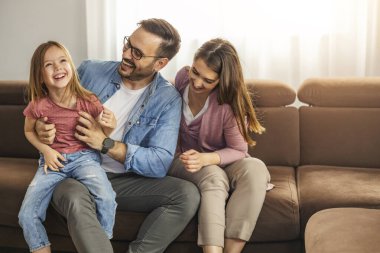  Neşeli anne, baba ve kız evde birlikte eğleniyorlar. Birlikte hafta sonunun tadını çıkarıyoruz..