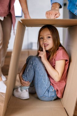 Genç bir aile için yeni bir hayata başlama kavramı. Karton kutuları olan mutlu bir aile. Mutlu aile yeni evine taşınıyor..