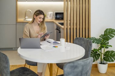 Dizüstü bilgisayar kullanan, e-posta yazan, çevrimiçi toplantı ya da ödeme yapan bir kadın. Ev ofisinden çalışan serbest çalışan biri..