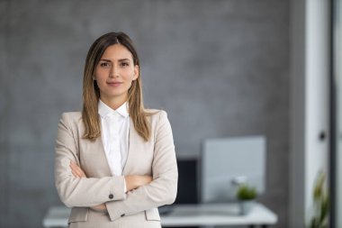 İş yerinde gülümseyen iş kadını. Ofiste poz veren ve kameraya bakan güzel genç bir iş kadını..