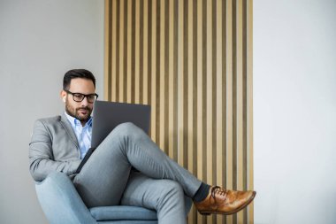 Evde dizüstü bilgisayarla çalışan genç bir iş adamı. İnsanlar, iş ve teknoloji kavramı. Online toplantı..