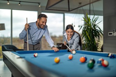 Erkekler ve kadınlar işe ara veriyorlar. İş arkadaşları işten sonra bilardo oynuyorlar..