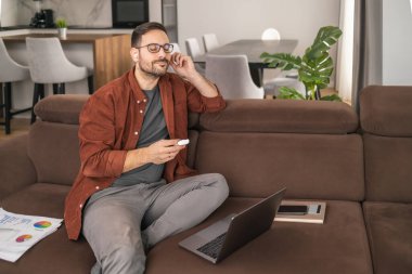 Evde çalışan serbest çalışan, yeni bir proje üzerinde çalışırken müzik dinleyen biri..