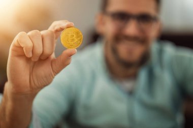 Gülümseyen çekici beyaz adam kameraya bitcoin gösteriyor. Çevrimiçi iş..